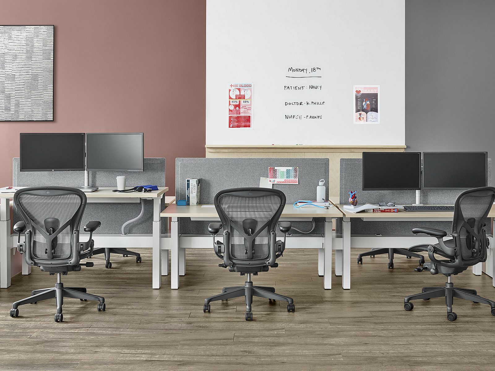 Well lit workspace with a two piece Renew Link and individual desk positioned against the wall with three Aeron chairs behind each work surface
